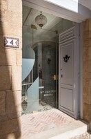 Entrada de hotel con puerta de vidrio, un candelabro y un letrero que dice "N° CUATRO BENISSA".
