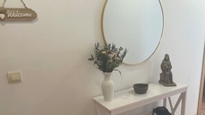 A white console table with a vase of flowers, a bowl, a statue, and two lanterns. - El Mirador de Sierra Mágina II ( ideal for family travel) (Noalejo)