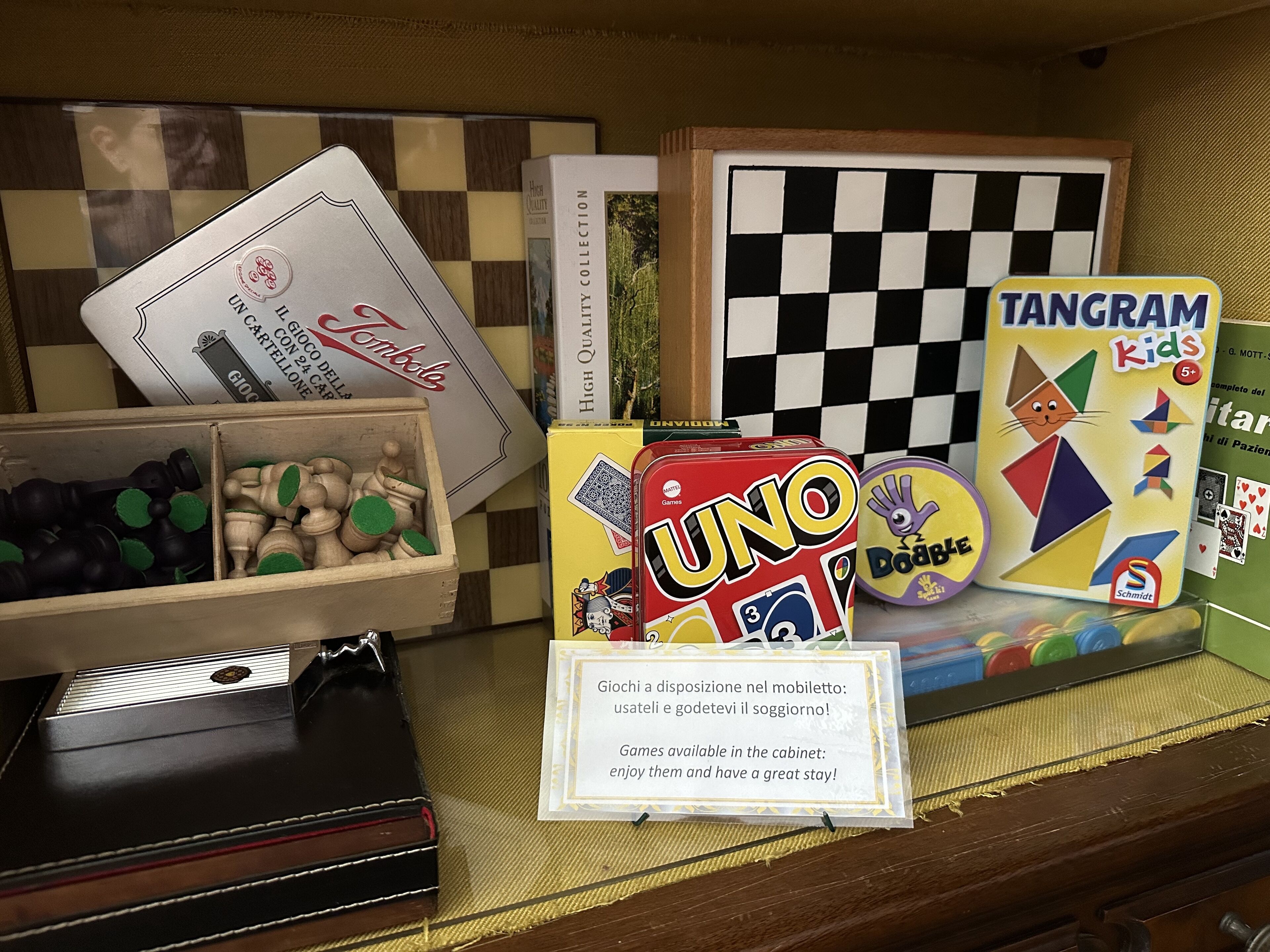 A display of board games including UNO, Tangram Kids, and others, with a sign indicating game availability.