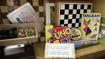 A display of board games including UNO, Tangram Kids, and others, with a sign indicating game availability.