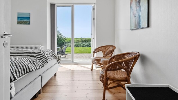 Een slaapkamer met een bed, een raam en uitzicht op de omgeving.