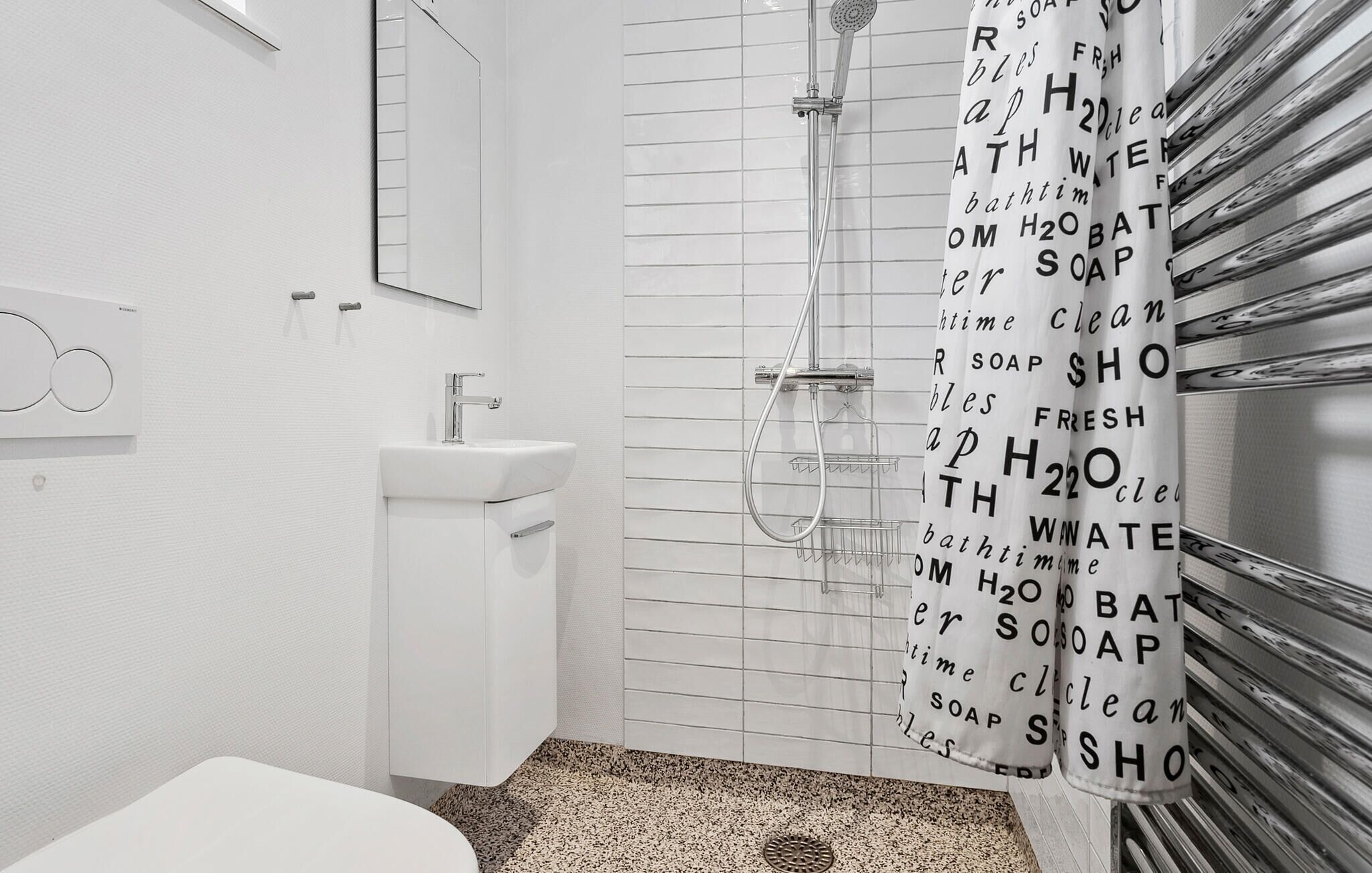 A modern bathroom with a shower, sink, and toilet.