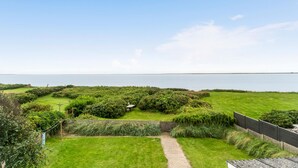 Een kusttuin met een pad dat leidt naar een gazon en uitzicht op zee.