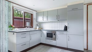 A kitchen with white cabinets, a built-in oven, and a coffee maker. - Gorgeous home in Erm with house sea view (Erm)