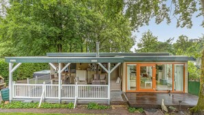 Un accogliente chalet con veranda, zona pranzo e soggiorno.