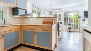 Una cucina moderna con mobili in legno, un forno a microonde e una finestra con persiane.