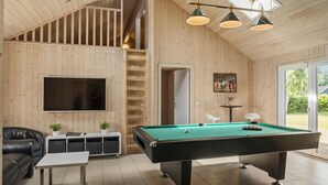 A spacious room with a pool table, a television, a sofa, and a staircase leading to an upper level. - Pet friendly home in Idestrup with sauna (Idestrup)
