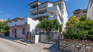 A modern two-story building with a stone facade, a gated entrance, and a balcony on the upper floor. - Luxurious home in Crikvenica with WiFi (Crikvenica)