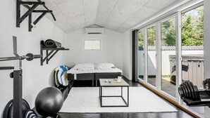 A gym with a bed, exercise equipment, and a view of the outdoors. - Amazing home in Thisted with sauna (Thisted)