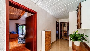 A hallway with a wooden door leading to a bedroom with a patterned rug, a white cabinet, and a potted plant. - 1 bedroom pet friendly apartment in Viganj (Viganj)
