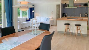 Une cuisine moderne dotée d’un îlot central, de meubles blancs et d’un mur d’accent bleu.