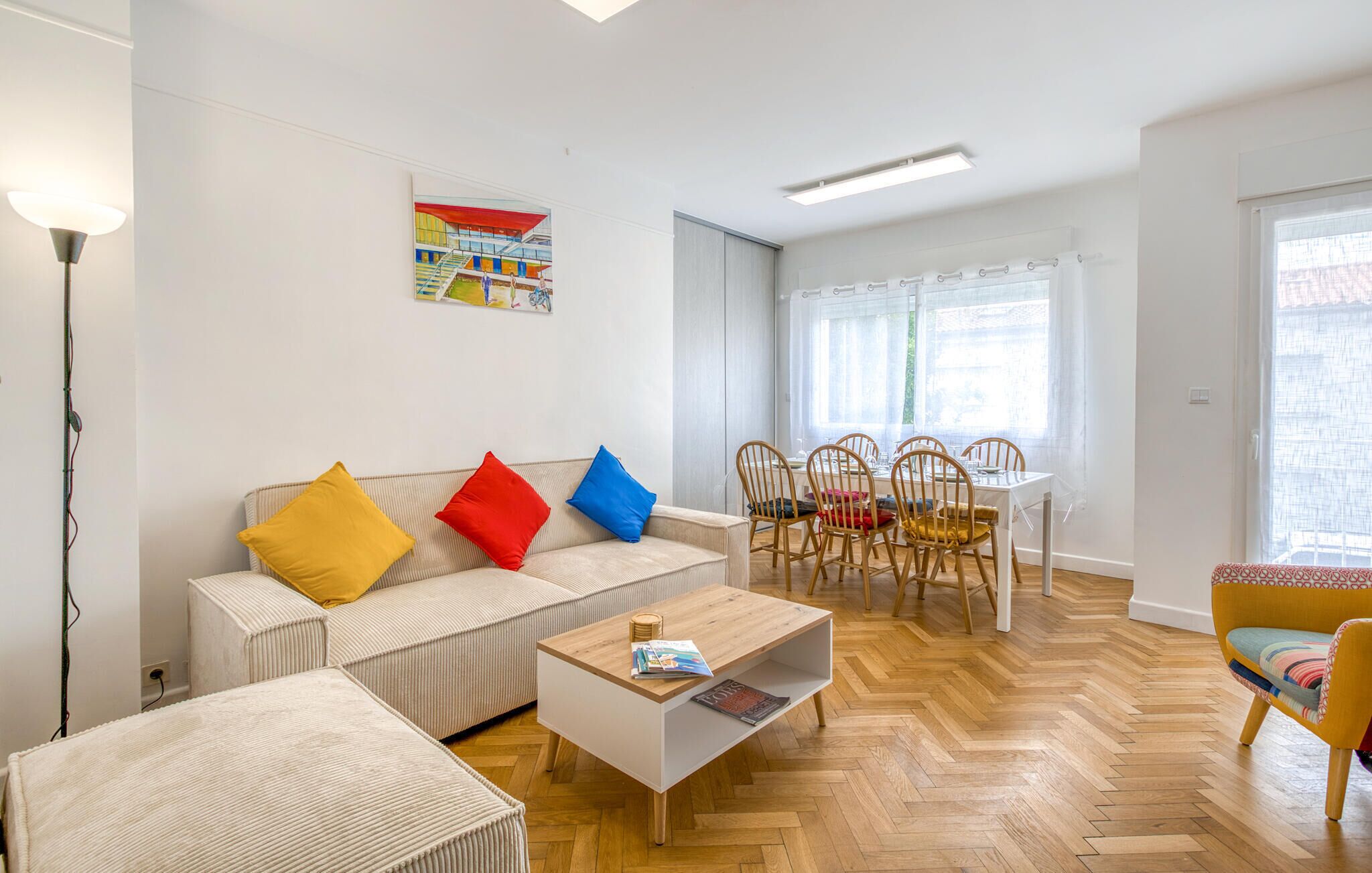 A modern living room with a sofa, coffee table, and dining area.