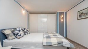 Un dormitori amb llit, almoinos, una taula de nit, una làmpada penjada a la paret i un quadre.