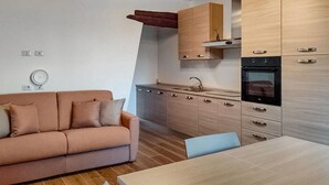 A compact living space with a sofa, a dining table, a kitchenette, and a small kitchen area. - Pet friendly apartment in Lubriano with sauna (Lubriano)
