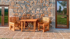 A stone wall with a Star of David, a wooden table with chairs, and a door leading to a garden. - Pet friendly apartment in Lubriano with sauna (Lubriano)