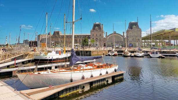 A marina with several boats docked, a large building with a clock tower, and a covered area with bicycles. - Pet friendly apartment in Oostende with WiFi (Oostende)