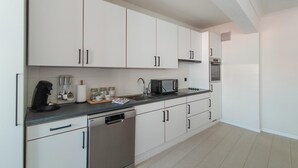 A modern kitchen with white cabinets, a stainless steel dishwasher, a microwave, and a built-in oven. - Pet friendly apartment in Oostende with WiFi (Oostende)