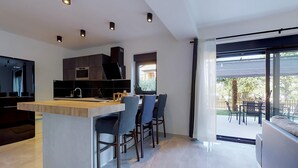 A modern kitchen with a central island, dark cabinetry, and recessed lighting. - Awesome apartment in Drenje (Drenje)