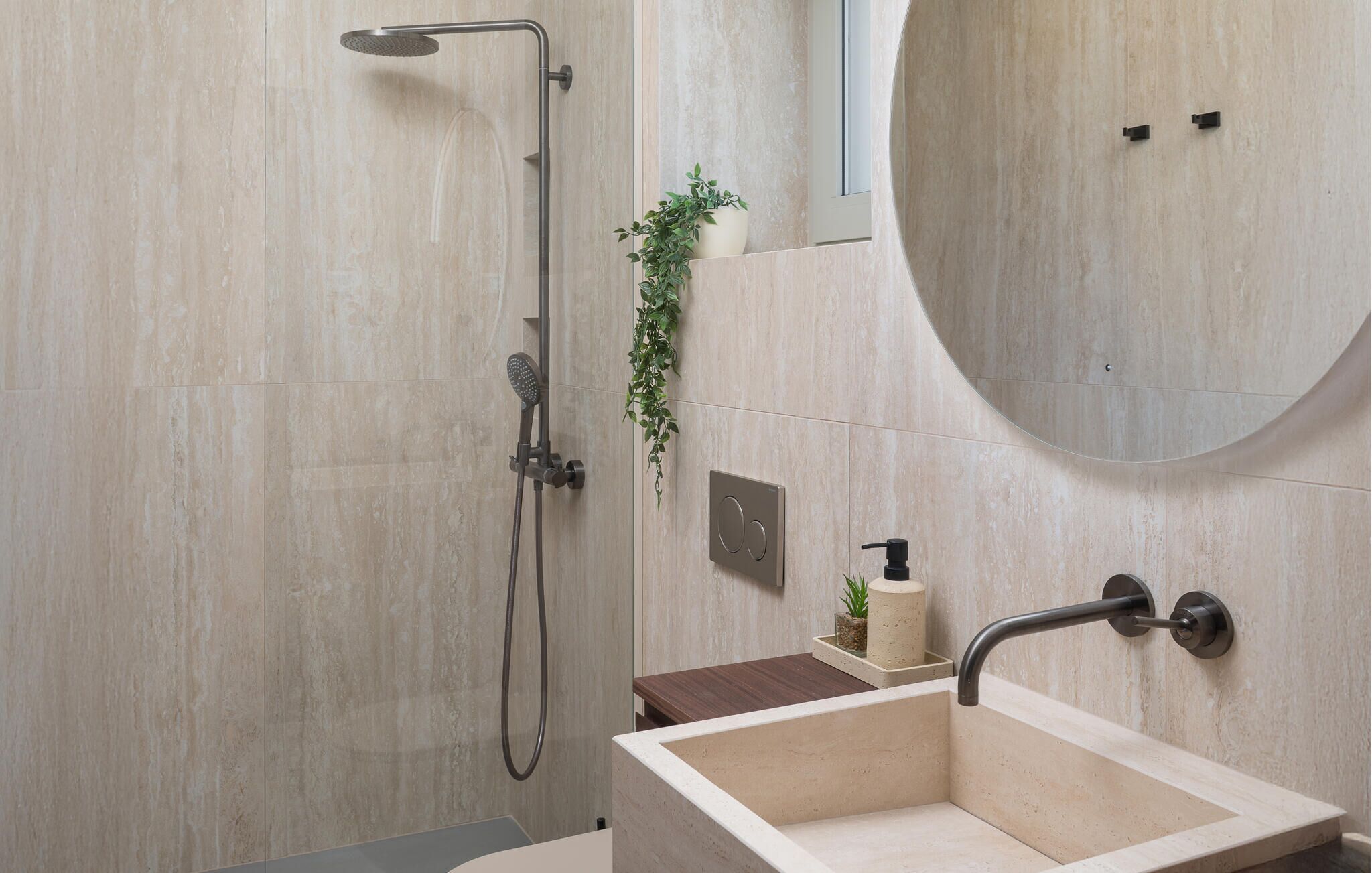A modern bathroom with a freestanding bathtub, a wall-mounted sink, and a shower with a handheld showerhead.