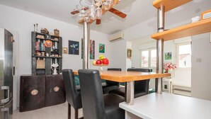 A modern kitchen with a central island, black chairs, and a wooden table. - Nice apartment in Omis with WiFi (Omis)