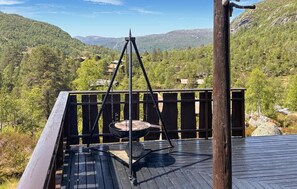 Una terraza con un columpio que da vista a un paisaje montañoso.
