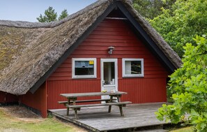 A red building with a thatched roof, a wooden bench, and a door with two windows. - Gorgeous home in Rømø with WiFi (Rømø)