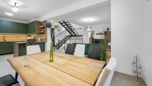 Una cocina moderna con armarios verdes, una encimera de madera y una estufa empotrada.