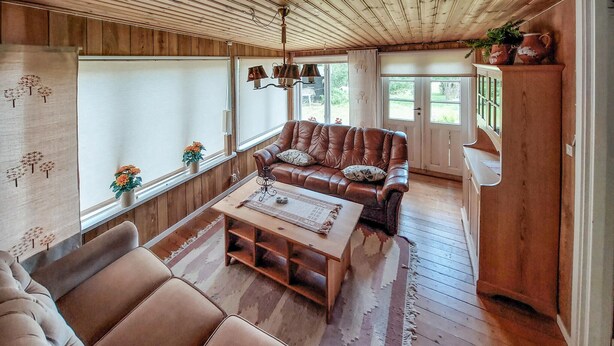 A cozy living room with a leather sofa, a wooden coffee table, and a rustic ceiling. - 1 bedroom gorgeous home in Ryssby (Ryssby)