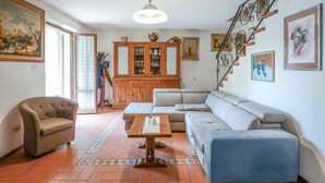 A living room with a sofa, armchair, and a wooden cabinet.