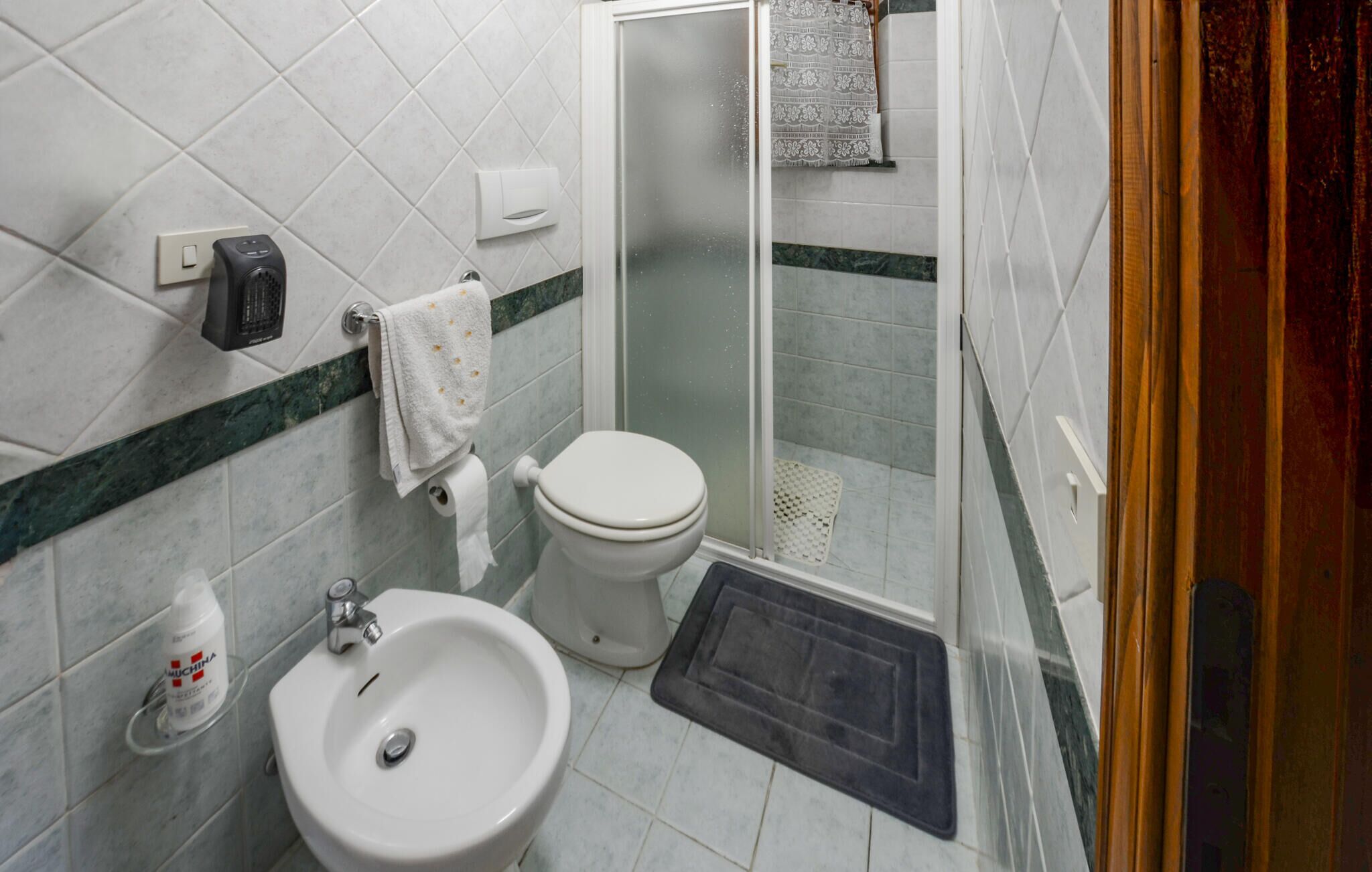 Une salle de bain équipée de toilettes, d’un bidet et d’un lavabo.