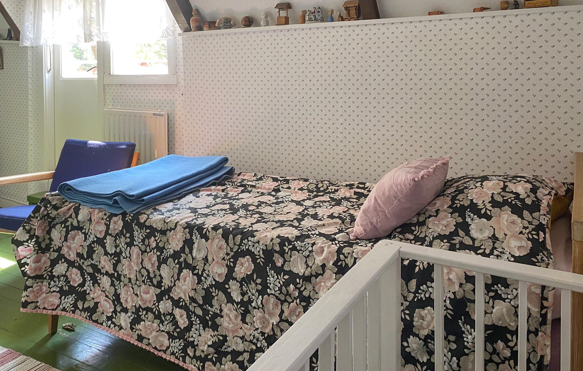 Une petite pièce confortable, avec un lit, une chaise et une fenêtre.