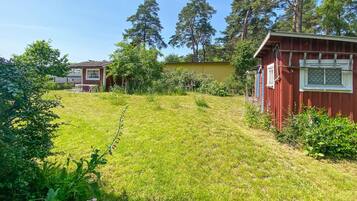 A residential area with two houses, one red and one yellow, surrounded by greenery and trees.