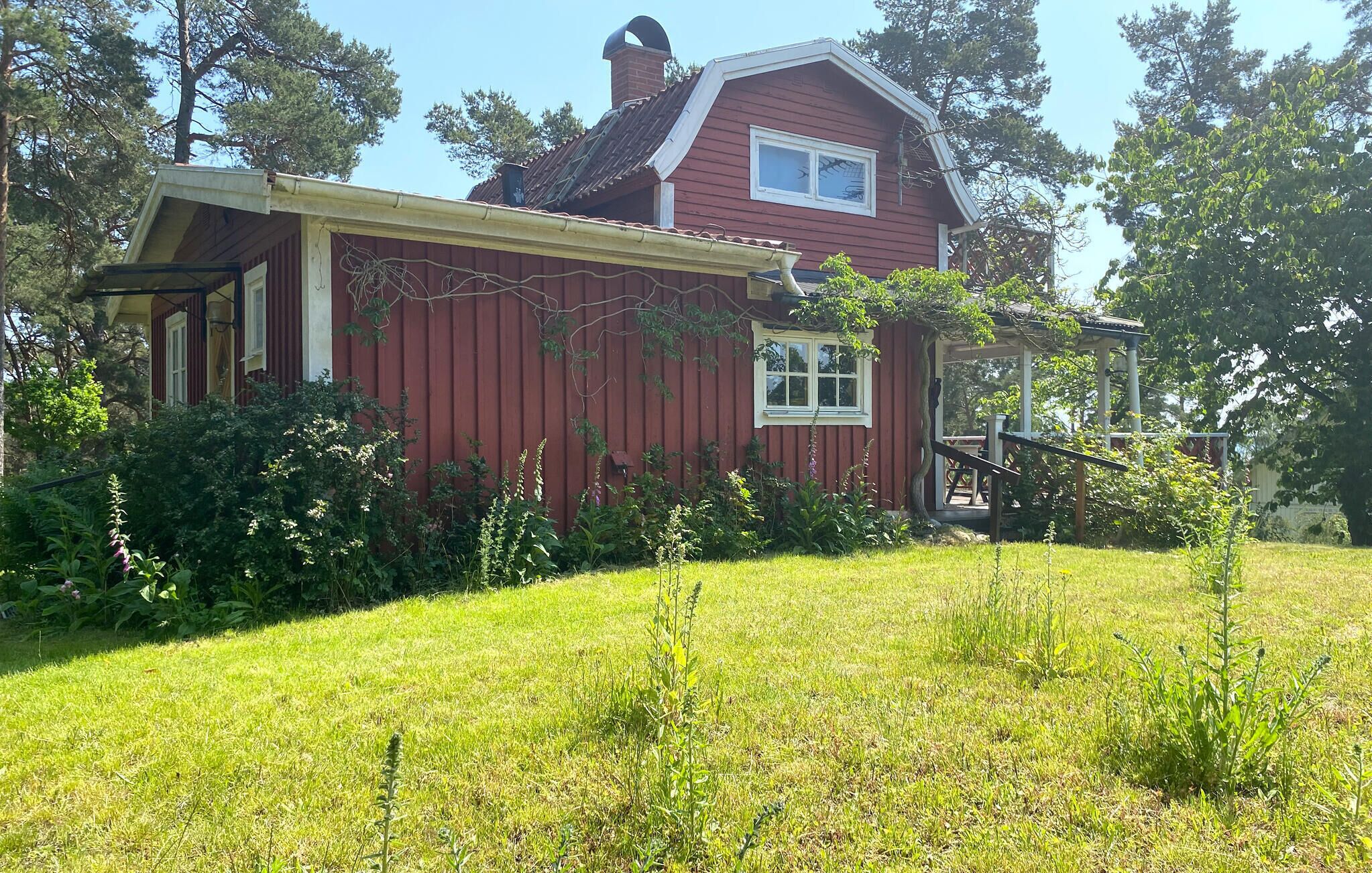 Punainen puutalo, jossa on valkoinen ikkuna ja pieni kuisti.