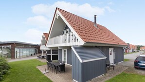 A two-story building with a red-tiled roof, a balcony, and a small attached shed. - Stunning home in Gråsten with sauna (Gråsten)