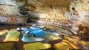 Un intérieur agrémenté d’une formation rocheuse naturelle et d’un élément décoratif aquatique réfléchissant.