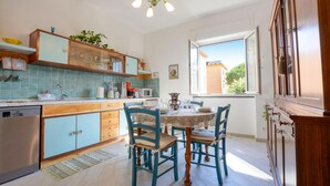 A kitchen with a dining area, wooden cabinets, a sink, and a window with a view. - 2 bedroom amazing apartment in Recco (Recco)
