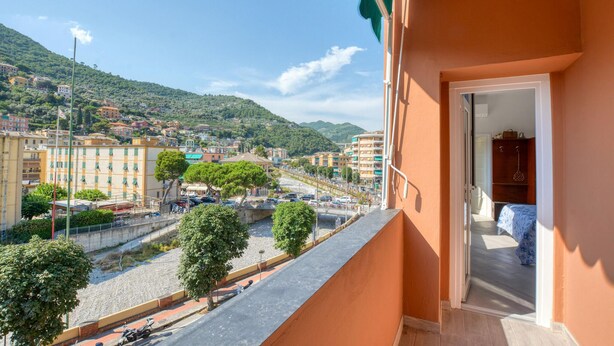 A balcony with a view of a coastal town, a paved street, and a hillside in the background. - 2 bedroom amazing apartment in Recco (Recco)