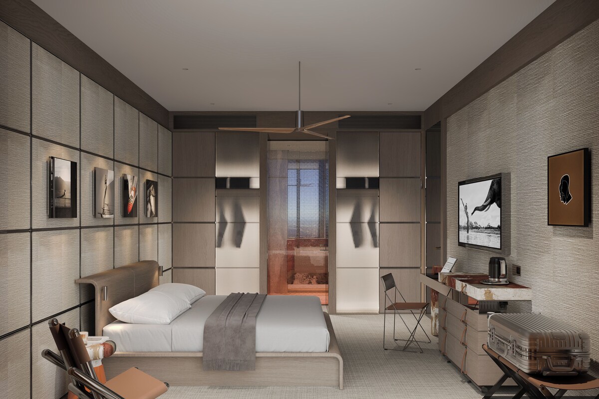 A modern bedroom with a bed, bedside tables, a desk, and a chair.