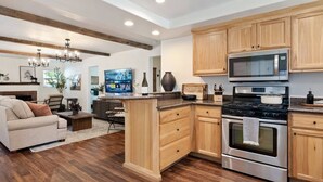 Une cuisine moderne avec des meubles en bois, des appareils électroménagers en acier inoxydable et un îlot central.