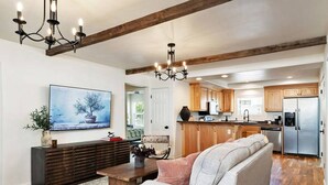 Un salon moderne avec un canapé, une table basse et un téléviseur fixé au mur.