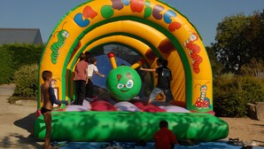 An inflatable play structure with cartoon characters and a green face. - SEA VIEW HOUSE FACING GLENANSR ISLANDS (LA FORET-FOUESNANT)