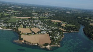 An aerial view of a coastal town with residential areas, fields, and a river. - SEA VIEW HOUSE FACING GLENANSR ISLANDS (LA FORET-FOUESNANT)