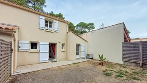 A two-story house with a gravel driveway, a small palm tree, and a wooden fence. - Beautiful home in Jard-Sur-Mer with WiFi (Jard-Sur-Mer)