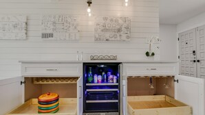 A kitchen with a built-in refrigerator, wooden drawers, and a wooden tray shelf. - Charming Ranch Home Near Dell With Cocktail Pool (Round Rock)