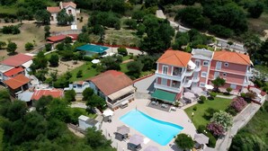 Vue aérienne d’un quartier résidentiel avec plusieurs maisons, une piscine et une pelouse bien entretenue.