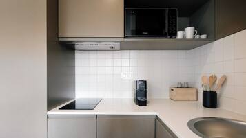 Frigorífico grande, microondas, placa de cocina y utensilios de cocina