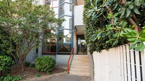 A pathway leading to a building with a staircase, surrounded by greenery and a white fence. - GuestHost - La Casa di Polly (Bitritto)