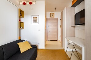 A modern living room with a sofa, a TV, and a wooden door. - GuestHost - La Casa di Polly (Bitritto)