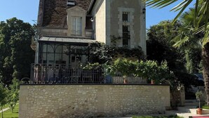 Uma casa grande com piscina em frente.