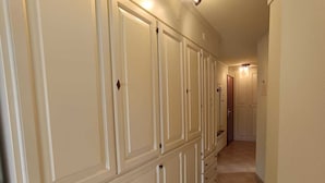 A corridor with a series of white cabinets and a tiled floor. - Functional apartment for 5 people with pets allowed, parking and south-facing balcony (Montgenèvre)